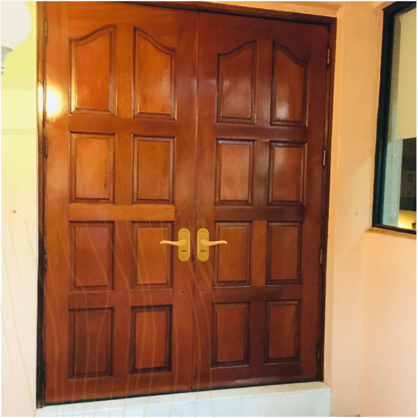 Set of paneled hardwood double doors with brass handles installed in a Florida home by MR Designer Services.
